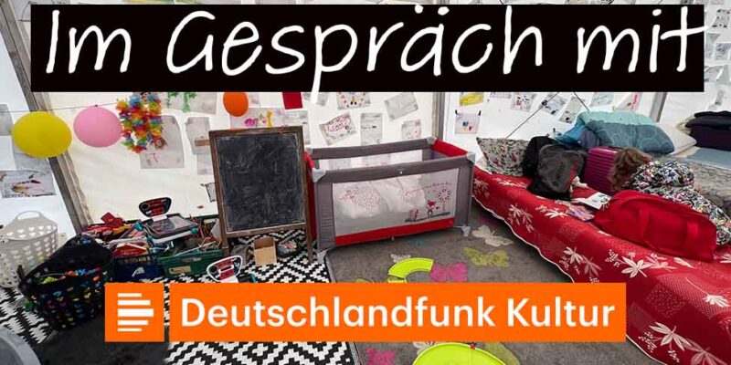Grafik „Im Gespräch mit Deutschlandfunk Kultur“ über einem Foto aus einer Notunterkunft mit Matratzen und Kinderzeichnungen.