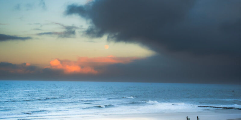 Sonnenaufgang über dem Meer mit breitem Wolkenband zum Jahreswechsel.