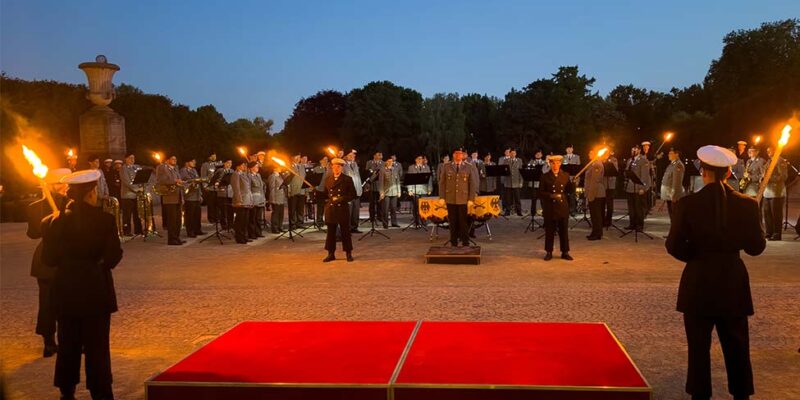 Fackelträger stehen in der Abenddämmerung beim Großen Zapfenstreich für Ministerpräsident Stephan Weil.