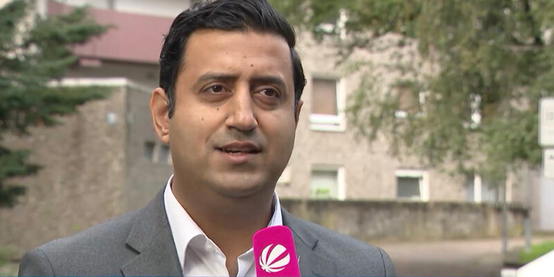 Dr. Wjahat Waraich im SAT.1-Interview vor Wohnhäusern im Sahlkamp, eingeblendet sein Name und sein Amt.