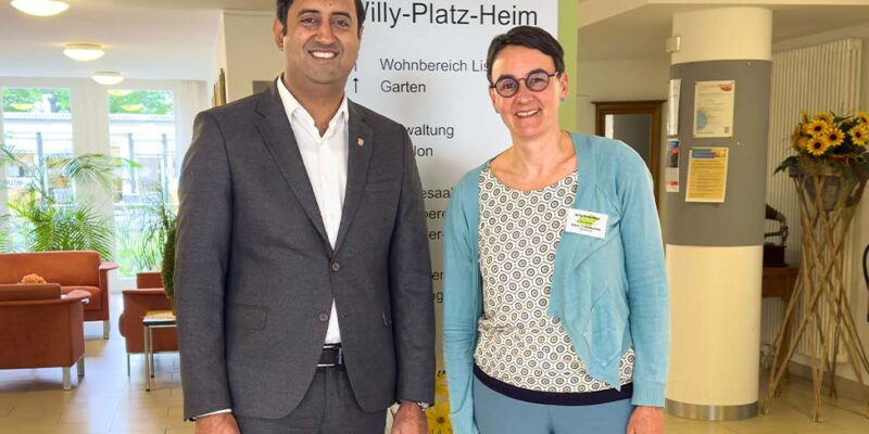 Dr. Wjahat Waraich steht mit einer Mitarbeiterin im Eingangsbereich des Pflegezentrums Willy-Platz-Heim.