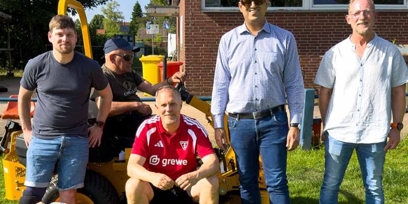 Dr. Wjahat Waraich steht mit Mitgliedern des TSV Fortuna-Sachsenroß am neuen Aufsitzmäher.