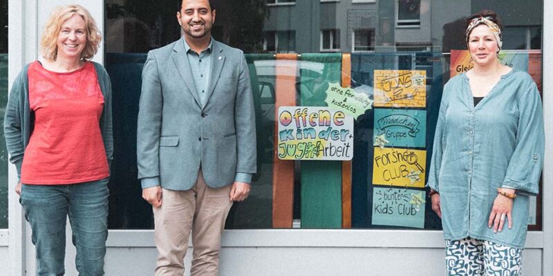 Dr. Wjahat Waraich steht mit zwei Mitarbeiterinnen vor dem Kids Club Vahrenheide.