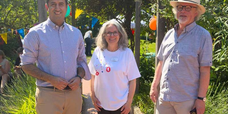 Dr. Wjahat Waraich steht mit zwei Gästen im Garten beim Fest zum 60-jährigen Bestehen der Kita Heilig Geist.
